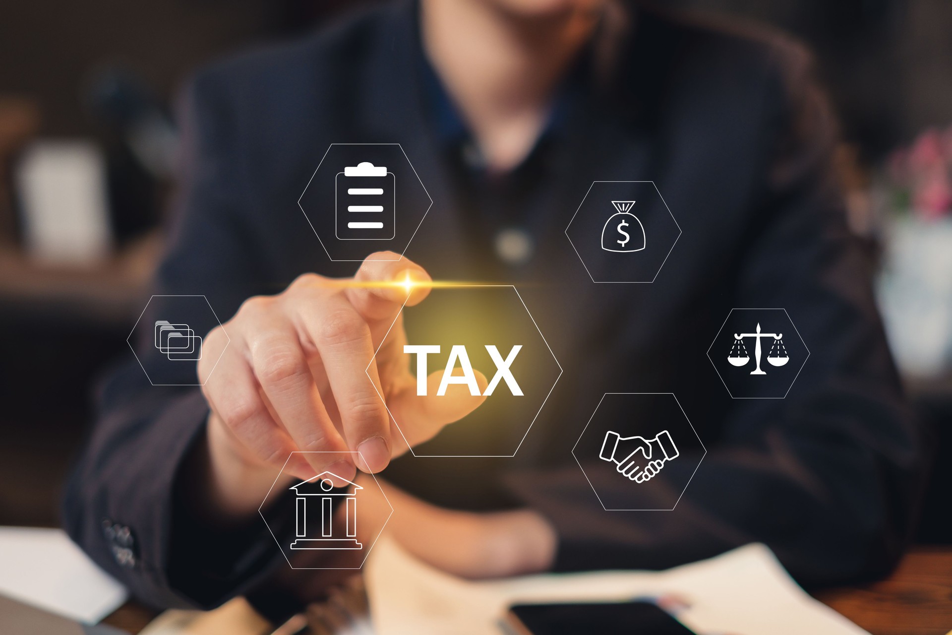 Businessman work on tax paper document, mobile phone and laptop to calculate to complete income tax return form online for tax payment. Data analysis, financial report. Tax deduction concept. VAT.
